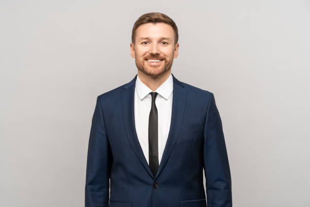 istock Smiling confident businessman looking at camera isolated on gray studio background with copy space 1731359399