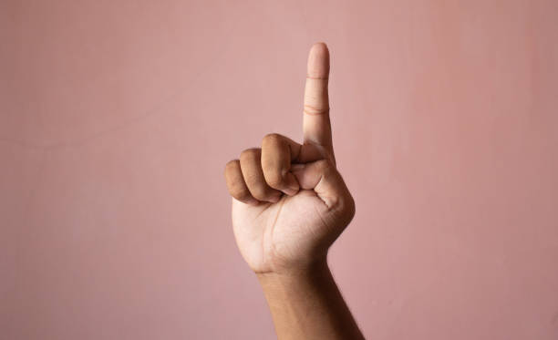 Man's hand with the index finger in pink background