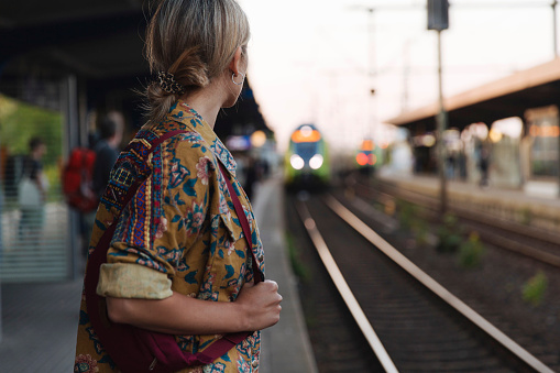 Young woman at the railway station waiting for her train