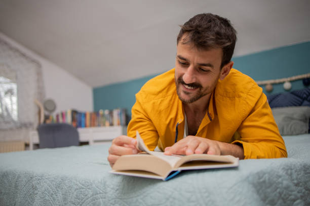 istock Man reading book at home 1731403174