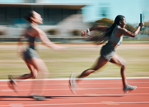 Action, race and women running relay sprint in competition for fitness game and training, energy or wellness on a track. Sports, stadium and athletic people or runner exercise, speed and workout