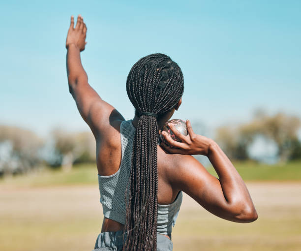 woman, shot put and athlete throw in competition, challenge or training in field event with metal or steel weight. throwing, ball or african female outdoor for athletics sport, game or strong contest - lançamento do peso imagens e fotografias de stock