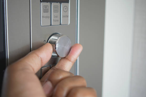 istock Close up of men hand setting temperature control on oven. 1731419018