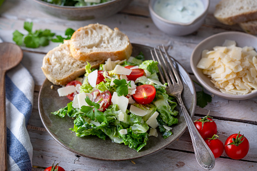 Green salad with tomatoes, bread and parmesan cheese