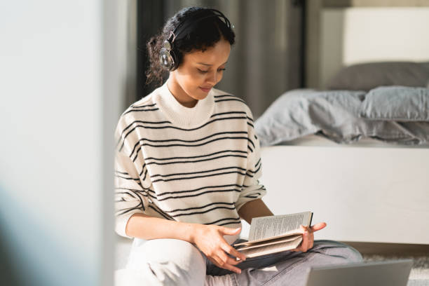 Female student sitting on the floor reading a book