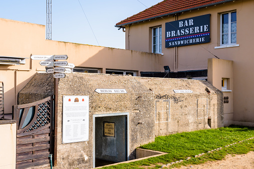 Sainte-Marie-du-Mont, France - Sept. 6, 2023: A former German bunker behind the bar brasserie Le Roosevelt at Utah Beach was used as a communication center by the US Navy during the Normandy landings.