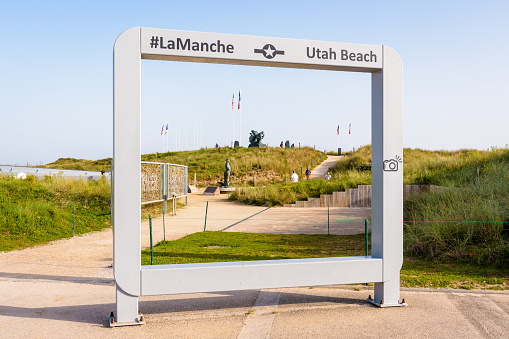 Sainte-Marie-du-Mont, France - Sept. 6, 2023: View through a large photo frame of the US Navy monument at Utah Beach, designed by american sculptor Steven Spears and installed in 2008.