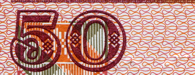 Australian 50 dollar bill fragment closeup showing the number fifty on yellow background