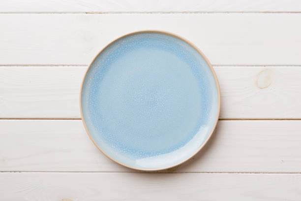 istock Top view of empty blue plate on wooden background. Empty space for your design 1731465251