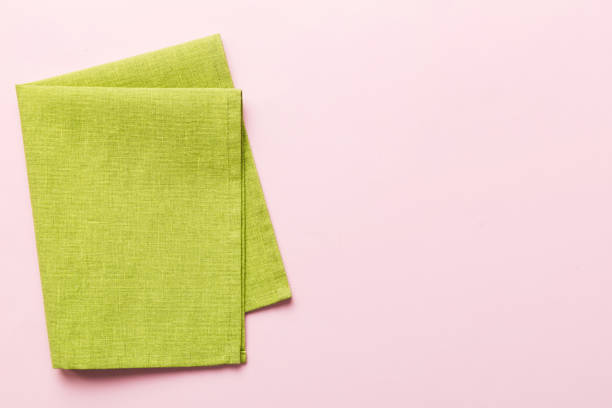 istock top view with green kitchen napkin isolated on table background. Folded cloth for mockup with copy space, Flat lay. Minimal style 1731465370