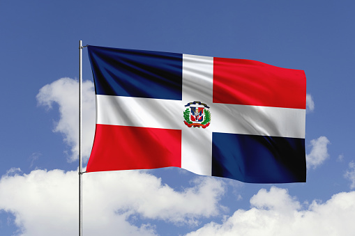 3d illustration flag of Dominican Republic. Dominican Republic flag isolated on the blue sky with clipping path.
