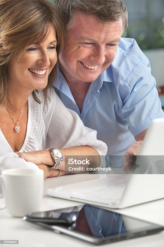 Счастливый зрелые пары с помощью беспроводной технологии - Стоковые фото 40-44 года роялти-фри