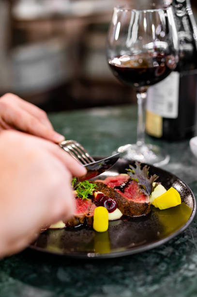 istock man hands eats meat with red wine in a restaurant 1731514335