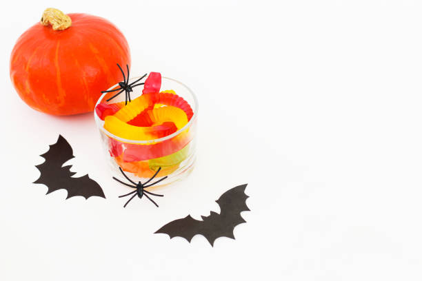 istock Pumpkin with jelly worms on a white table, Halloween concept 1731529826