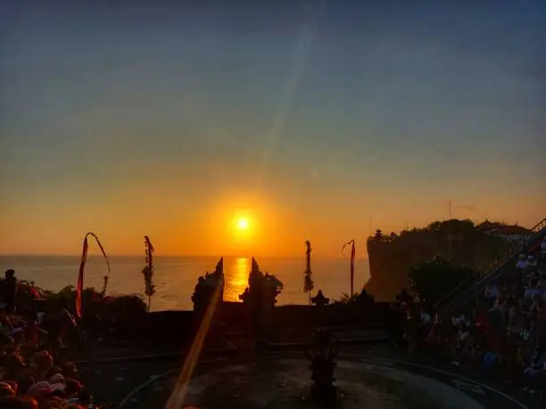 Photo of Balinese Kecak dance performance with a sunset background