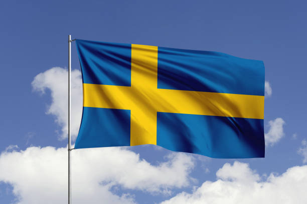 флаг швеции развевается на ветру в небе. - day sky swedish flag banner стоковые фото и изображения