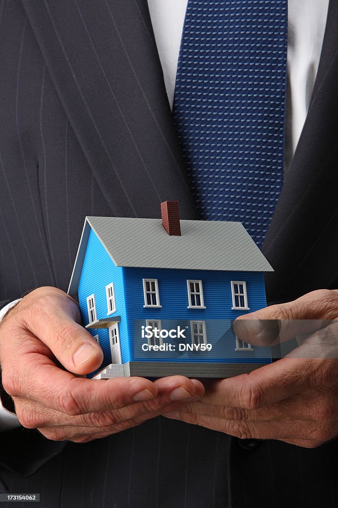 Real Estate A man holding a house in his hands. Business Stock Photo