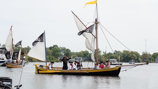 Orillia, Canada – September 03, 2023: Men dressed as pirates on a wooden ship replica putting on a show for the Orillia Pirate festival on Lake Couchiching