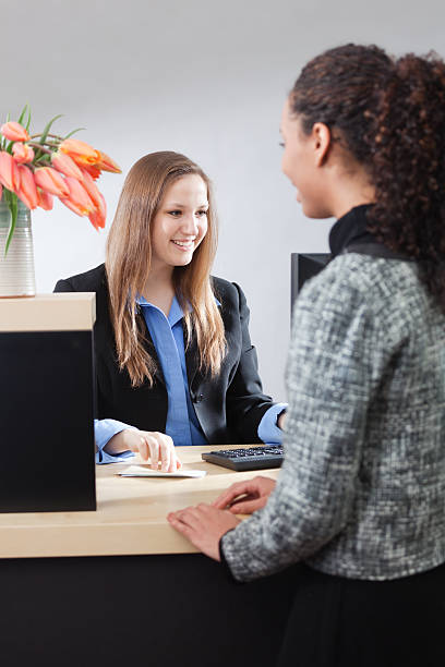 istock Friendly Smiling Bank Teller Helping Customer at Counter Window Vt 173155286