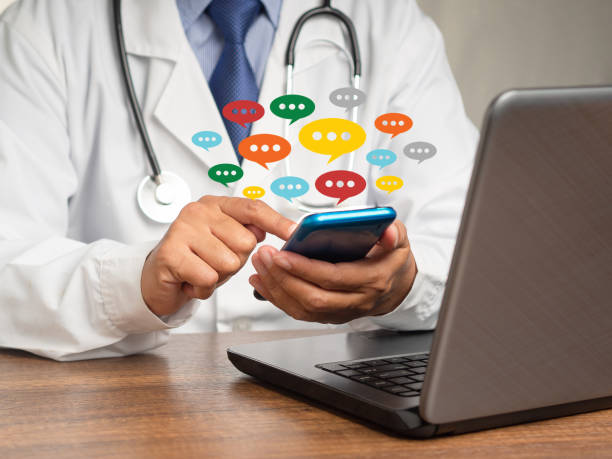 istock Doctor in a uniform using a smartphone with colorful chat icons on application digital web and social media while sitting at the table 1731553035