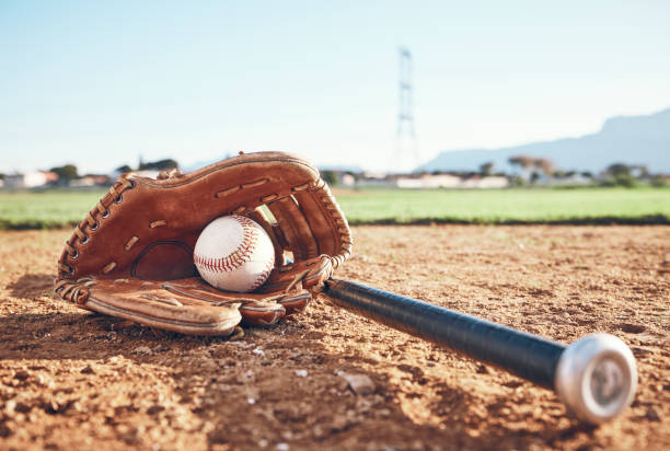 guanti, mazze e attrezzatura da baseball sulla sabbia per una partita, una competizione professionale o uno sport. terreno, fitness e attrezzature per una partita, fitness o allenamento per il softball sulla sabbia in estate per il cardio - softball baseball glove sports equipment outdoors foto e immagini stock