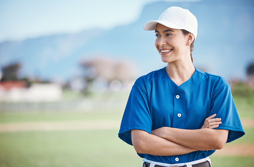 Sports, baseball and woman with arms crossed on a field for training, match or fitness goals on blurred background. Happy, softball and female coach at park with motivation, proud or positive mindset