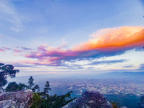 This evocative landscape photograph transports you to the picturesque landscapes of Chaiyaphum, Thailand, where the mountains and the captivating orange skies create a scene of serene magnificence.