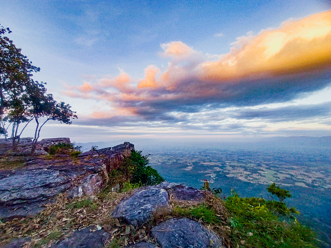 This evocative landscape photograph transports you to the picturesque landscapes of Chaiyaphum, Thailand, where the mountains and the captivating orange skies create a scene of serene magnificence.