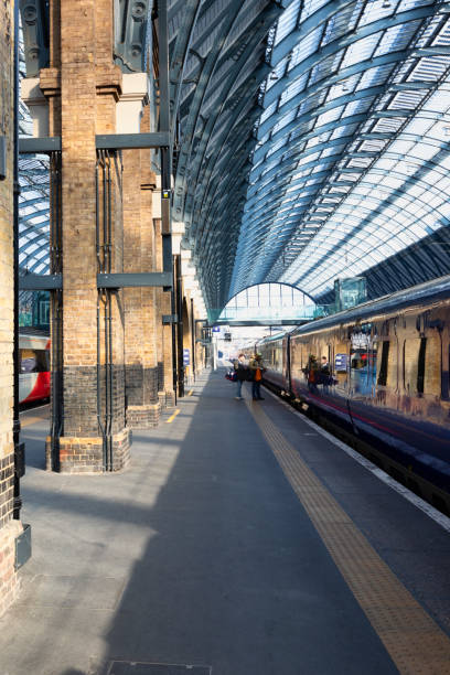 London. UK - Feb 24, 2018: A passenger train stands by the platform at Kings Cross in London, while a blur of commuters pass through the station.