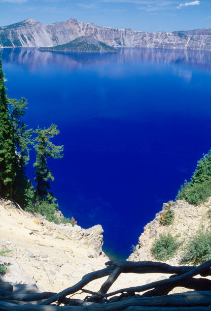 Crater Lake is a volcanic crater lake in south-central Oregon.  The lake is famous for its deep blue color and water clarity and is the deepest in the United States.  Two small islands, Wizard Island, which is a cinder cone and Phantom Ship, a natural rock pillar.
