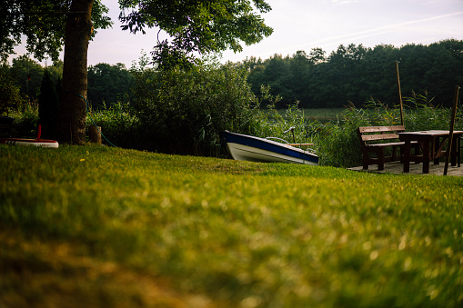 Picturesque summer lake calm beach with camping pitch on shore. Concept of tranquil country life, eco friendly tourism, camping, fishing