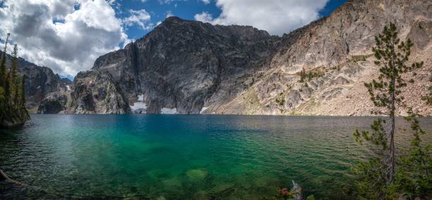 a lake that has some clear water with mountains in the background
