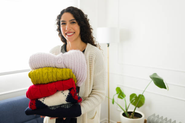 istock Gorgeous young woman folding sweaters and winter clothes 1731580639