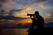 silhouette of a photographer with dramatic cloudy sky