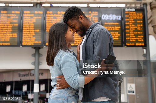 istock young family couple at the train station exited about oncoming travel in front of timetable Passengers traveling,  journey concep 1731590084