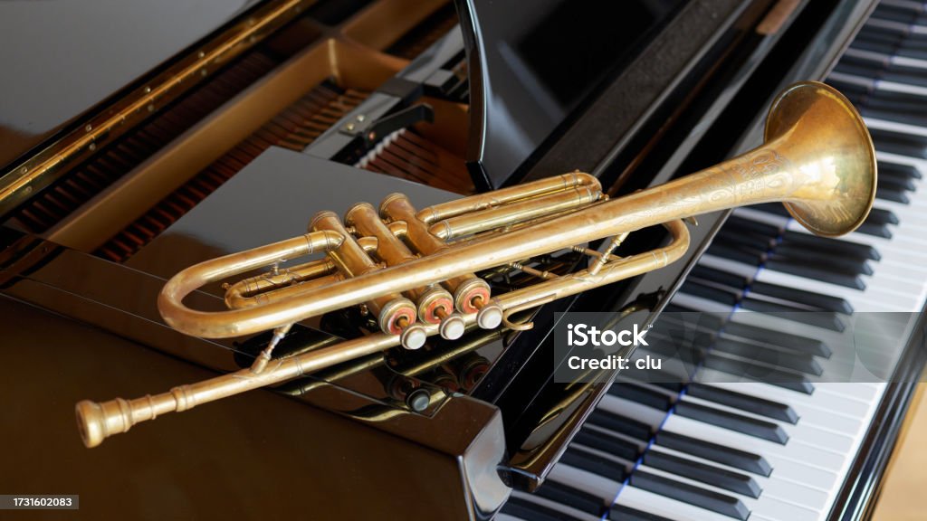 Piano keys and a trumpet lying on top Trumpet Stock Photo