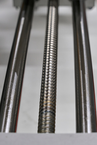 Three vertical steel bars. The middle one is threaded.