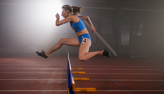 Athlete Woman Preparing And Runs Hurdles for Track and Field