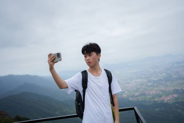 istock Man taking selfie with smartphone on top of mountain 1731613342