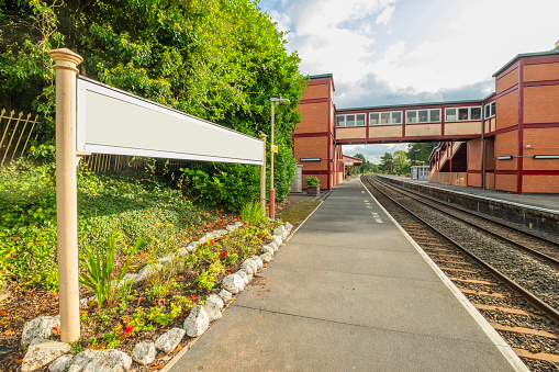 A station England UK. Diesel powered railway line in the English countryside. Station on a sunny day.