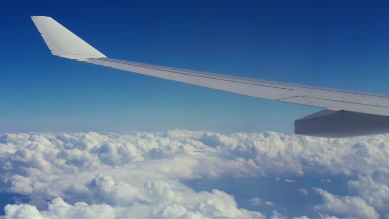 Airplane wing flying over the sea of clouds