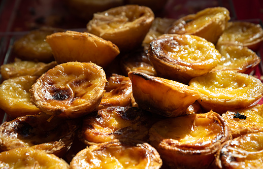 Pastel de nata or Pastel de Belem egg custard tart pastry at traditional Portuguese food festival. Sweet indulgence background. Selective focus.