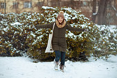 happy modern woman outdoors in city park in winter