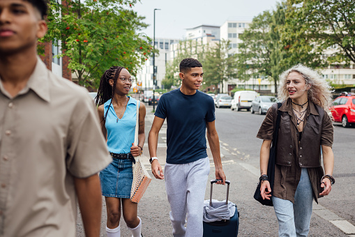 Group of university students carrying luggage while moving into their university dorm.  They are in Newcastle Upon Tyne.