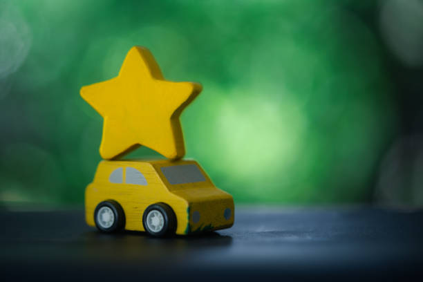 Eco-car concept. Wooden toy car. Fresh green tree background.