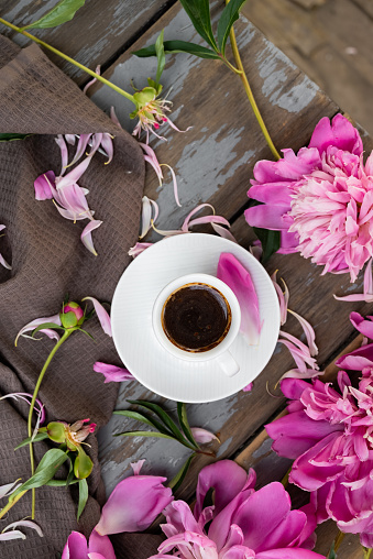 Still life with peonies and a coffee cup on a dark background. A gift card. Wedding card.