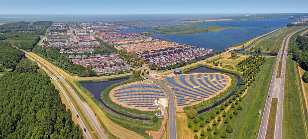 Aerial panorama from a solar Panel Farm with unique design in a form of an island (Zoneiland). Energy is used to power city heating (stadswarmte) in a modern sustainable district Noorderplassen in Almere, The Netherlands.