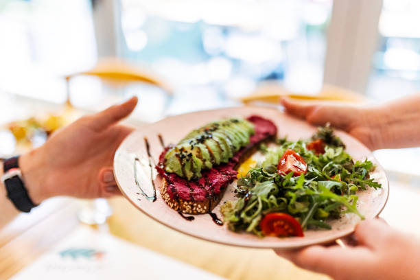 istock Waitress Delivers a Dish to a Young Man 1731809603