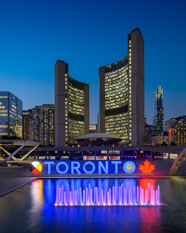 Toronto, Ontario, Canada - July 19 2021 : Fountain at Nathan Phillips Square. Toronto Sign. Toronto Old City Hall.