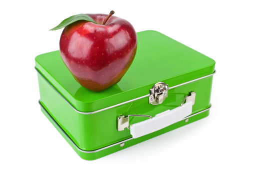 Bright red apple and a lunchbox for Back to School.  Shallow dof, isolated on white